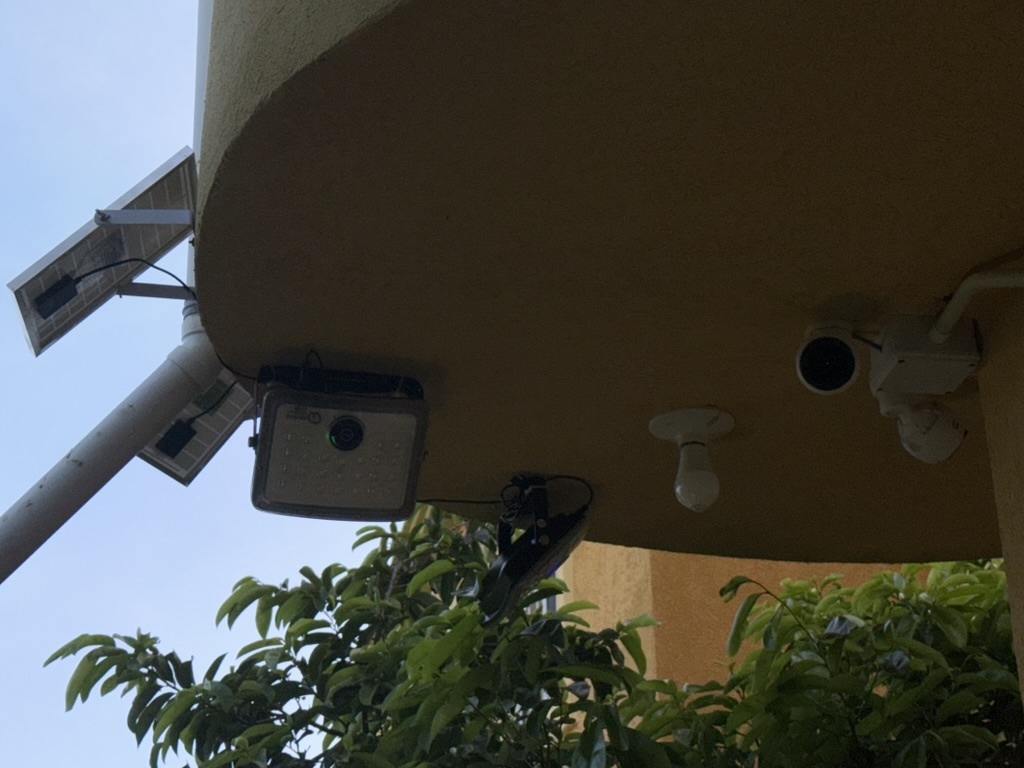 Solar-powered camera and UniFi G3 Flex mounted on building exterior with conduit run